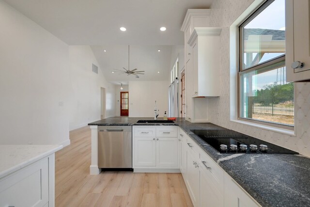 2 Cherokee Trl, Wimberley, TX 78676 - kitchen with stainless steel dishwasher, a sink, a peninsula, light wood-type flooring, and vaulted ceiling