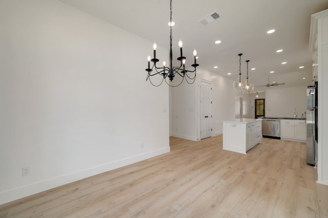 kitchen featuring a kitchen island, light hardwood / wood-style flooring, white cabinets, pendant lighting, and appliances with stainless steel finishes