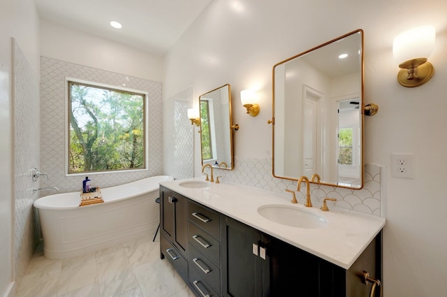 bathroom featuring vanity, backsplash, and a bathing tub