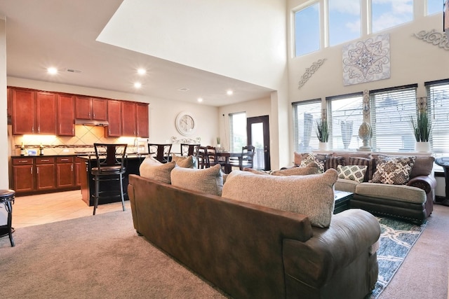 carpeted living room featuring a high ceiling and a wealth of natural light