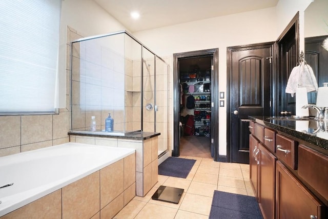 full bath with tile patterned flooring, a garden tub, a shower stall, and vanity