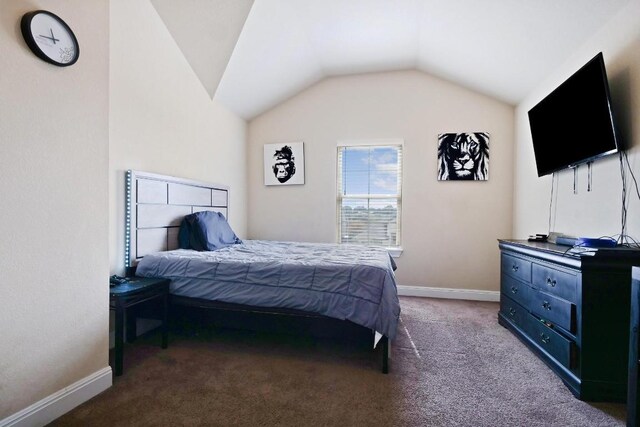 bedroom featuring lofted ceiling and carpet