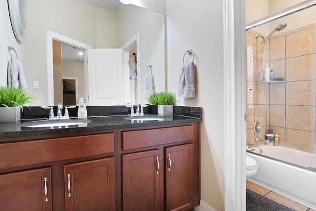 bathroom with  shower combination, double vanity, toilet, and a sink