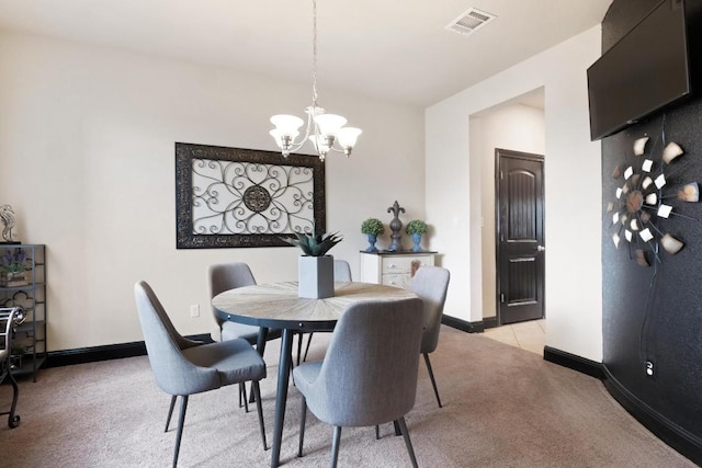 dining room with light carpet, a chandelier, visible vents, and baseboards