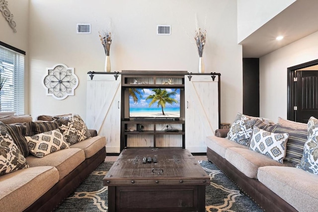 living room with visible vents and a barn door