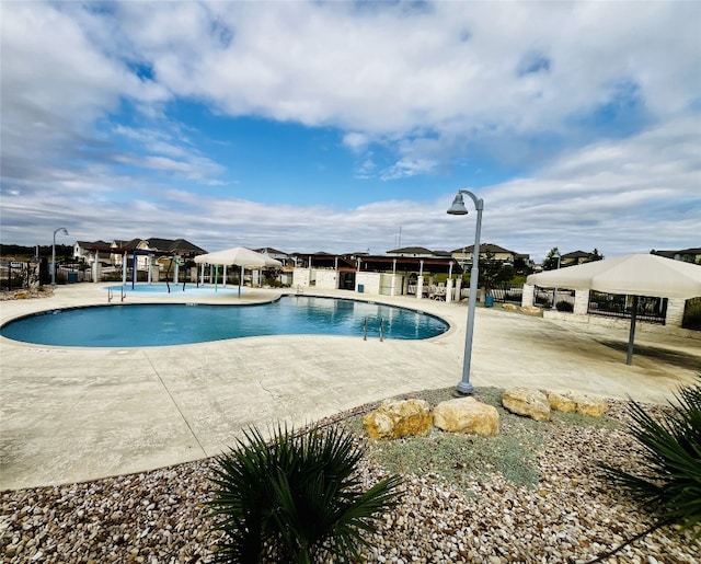 community pool featuring a patio area, fence, and a gazebo