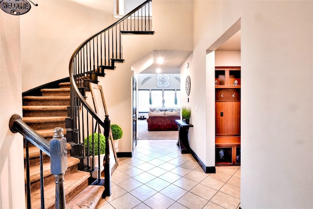 stairs with a high ceiling and tile patterned flooring