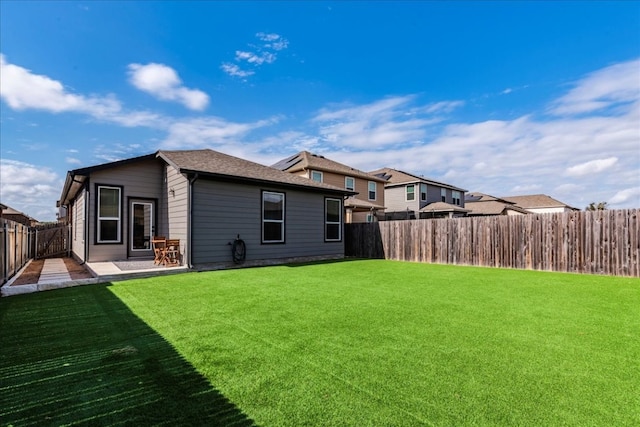 rear view of property featuring a patio area and a lawn