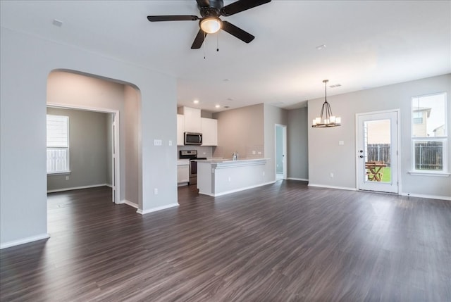 unfurnished living room featuring dark hardwood / wood-style floors, sink, and ceiling fan with notable chandelier