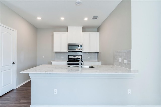 kitchen featuring appliances with stainless steel finishes, sink, kitchen peninsula, white cabinets, and dark hardwood / wood-style floors