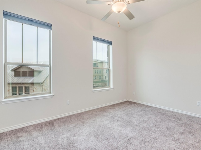 spare room featuring light carpet and ceiling fan