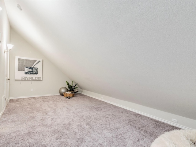 bonus room with light carpet and vaulted ceiling