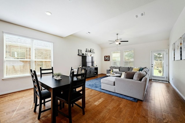 dining space with ceiling fan, wood-type flooring, and lofted ceiling