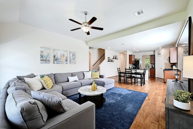 living room featuring hardwood / wood-style floors, vaulted ceiling, and ceiling fan