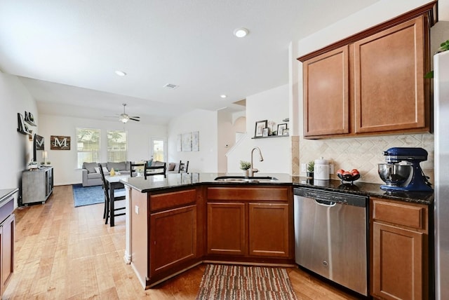 kitchen with dishwasher, dark stone counters, sink, tasteful backsplash, and kitchen peninsula