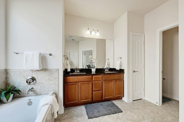 bathroom with tile patterned floors, vanity, and a tub