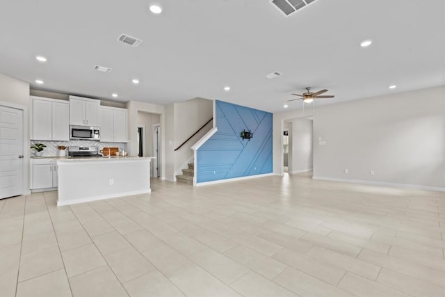 unfurnished living room featuring ceiling fan