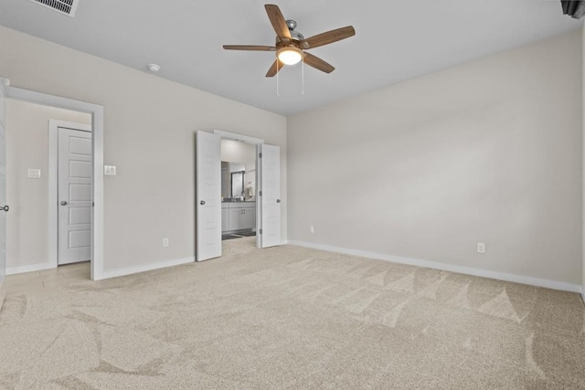 unfurnished bedroom with light carpet, ensuite bathroom, and ceiling fan