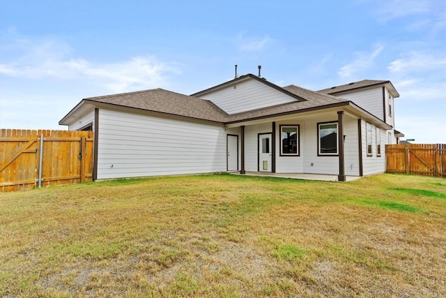 back of house with a patio area and a lawn