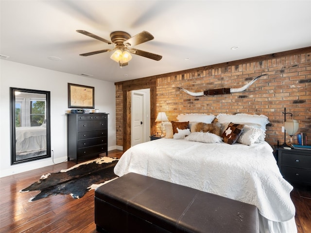 bedroom with brick wall, wood-type flooring, and ceiling fan