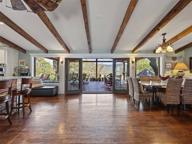 dining space with dark hardwood / wood-style floors, beamed ceiling, and plenty of natural light