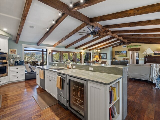 kitchen featuring beverage cooler, vaulted ceiling with beams, dark hardwood / wood-style flooring, a large island, and white cabinets