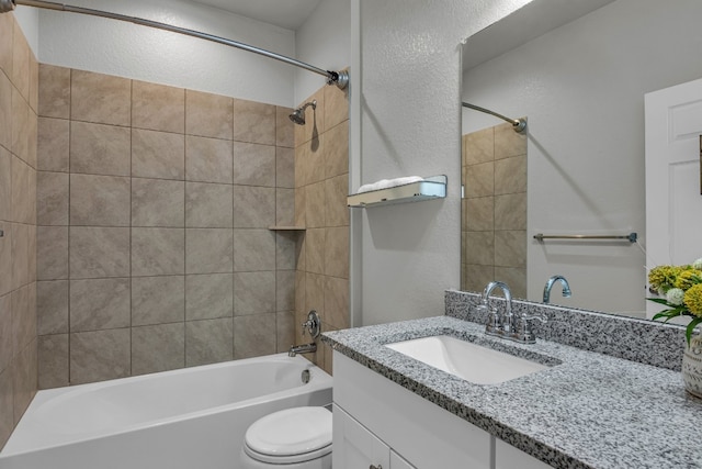 full bathroom with toilet, vanity, and tiled shower / bath