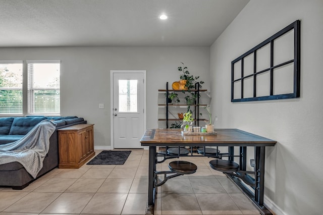 foyer entrance with a textured ceiling and light tile patterned floors