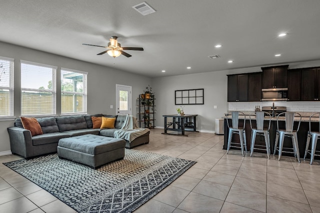 living room featuring ceiling fan and light tile patterned flooring