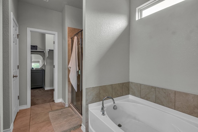 bathroom with tile patterned floors and shower with separate bathtub