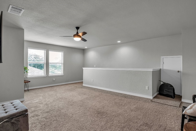 carpeted living room featuring a textured ceiling and ceiling fan