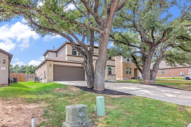 view of front facade featuring a garage, a front lawn, and central AC unit