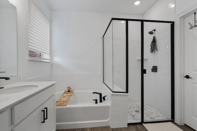 bathroom featuring vanity, separate shower and tub, and hardwood / wood-style flooring