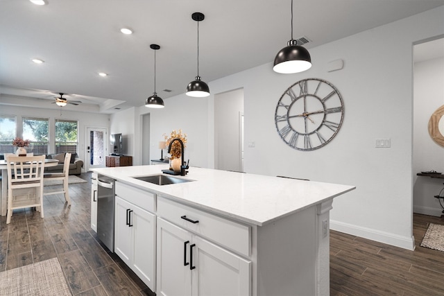 kitchen with sink, dark hardwood / wood-style flooring, hanging light fixtures, white cabinets, and a kitchen island with sink