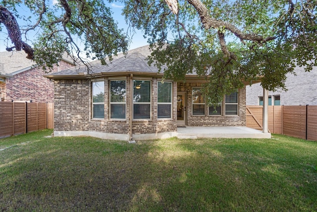 back of property with a patio area and a lawn