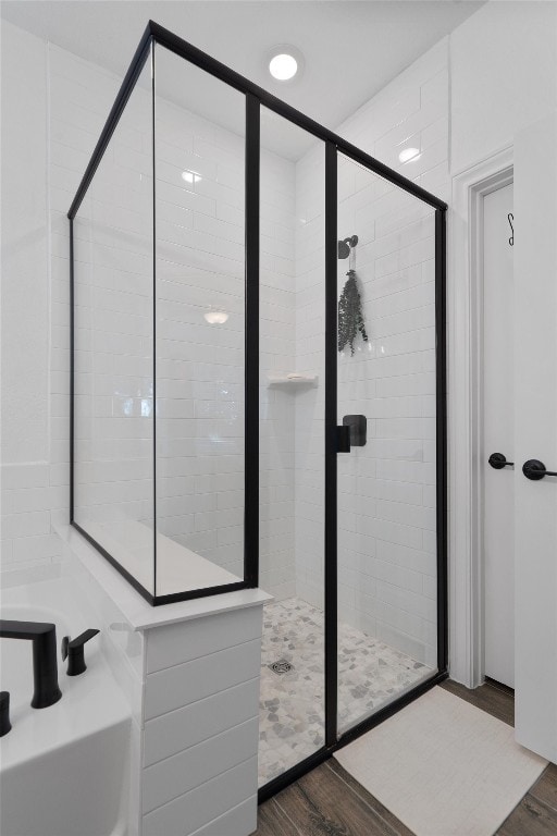 bathroom featuring hardwood / wood-style flooring and walk in shower