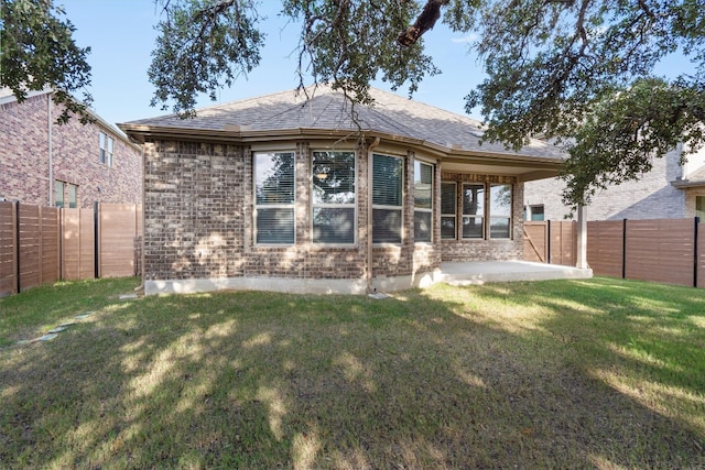 back of property featuring a patio area and a lawn