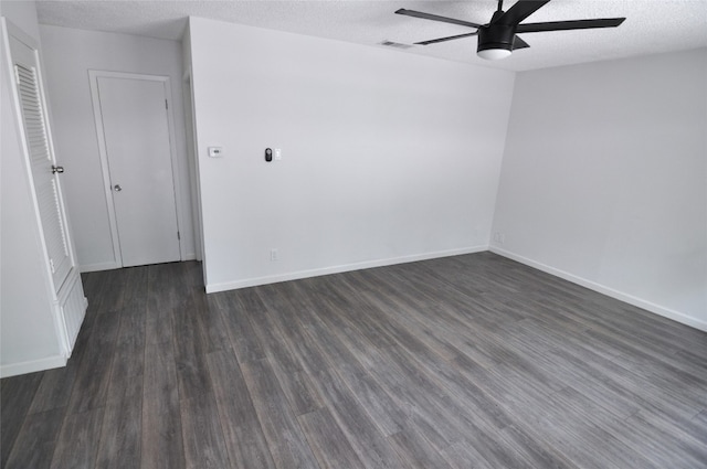 spare room with a textured ceiling, ceiling fan, and dark hardwood / wood-style flooring