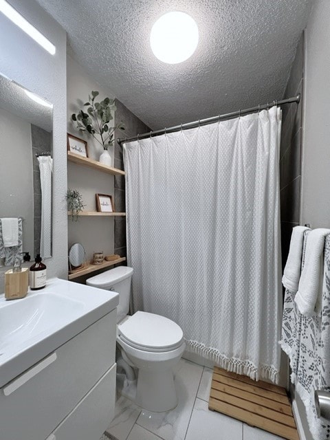 bathroom with vanity, a textured ceiling, toilet, and walk in shower