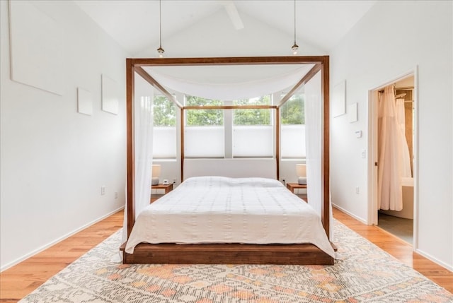 bedroom with light wood-type flooring and vaulted ceiling