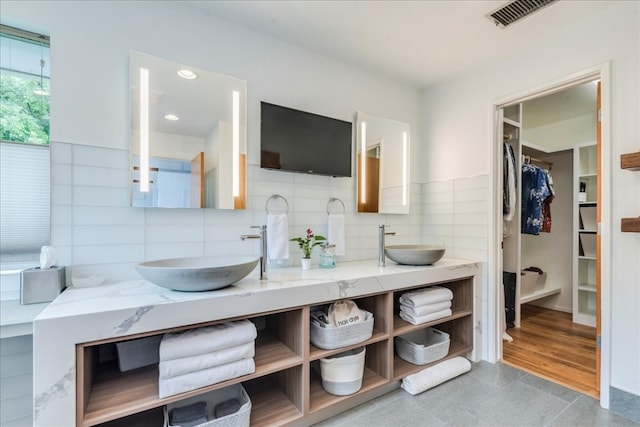 bathroom featuring tile patterned floors, decorative backsplash, and vanity