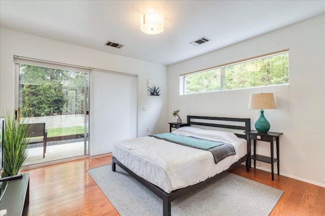 bedroom with access to outside and light hardwood / wood-style flooring