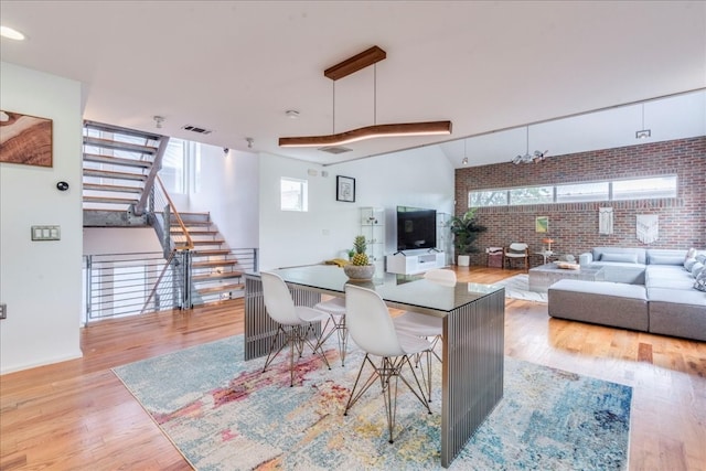 interior space with brick wall and light hardwood / wood-style flooring