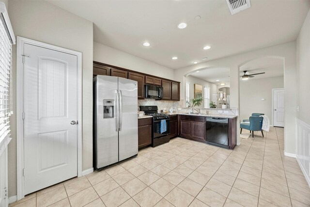 kitchen with tasteful backsplash, dark brown cabinets, light tile patterned floors, ceiling fan, and black appliances