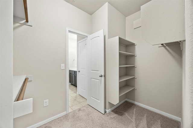 walk in closet featuring light tile patterned floors and light colored carpet