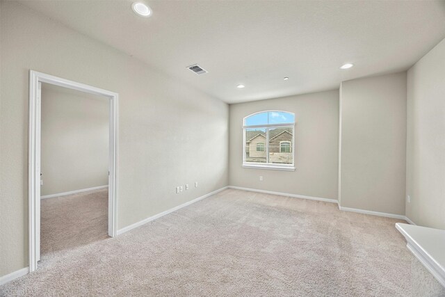 unfurnished room featuring light colored carpet