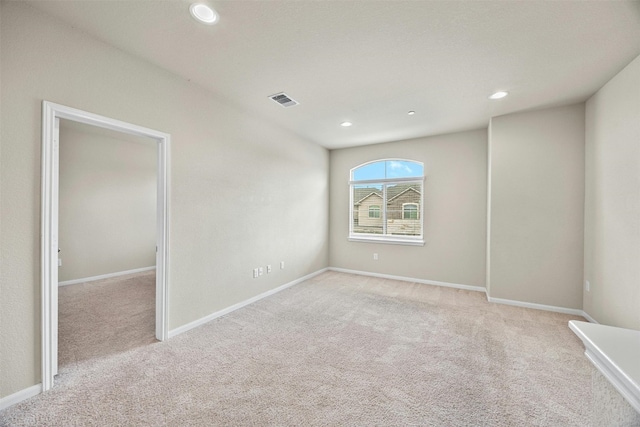 empty room featuring light colored carpet, recessed lighting, visible vents, and baseboards