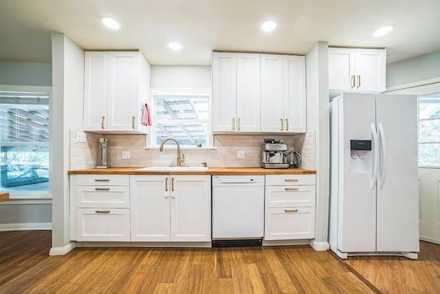 kitchen featuring white appliances, butcher block counters, and white cabinets