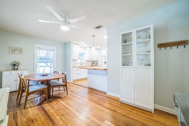 dining area with sink, ceiling fan, and light hardwood / wood-style flooring