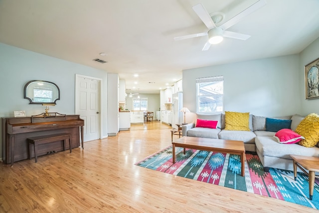 living room featuring ceiling fan and light hardwood / wood-style floors